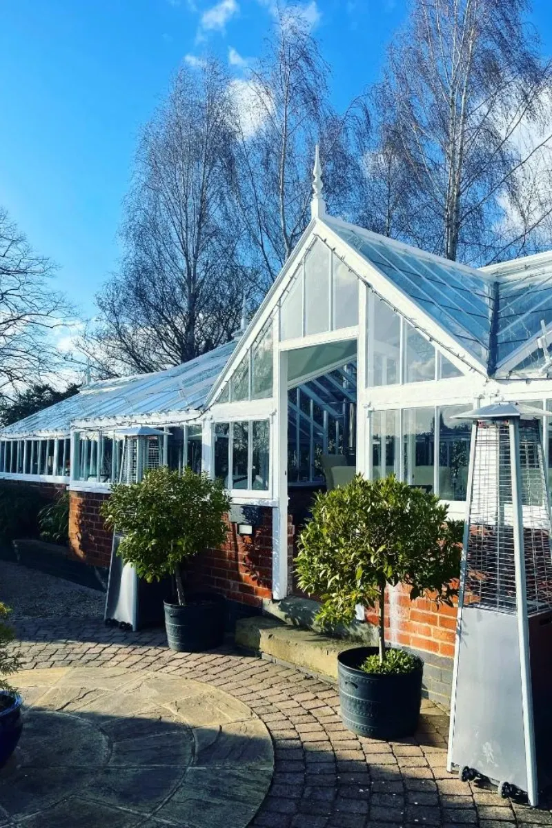 The Victorian glasshouse in winter sun, with potted bay trees outside